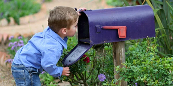 copil se uita in cutia de scrisori